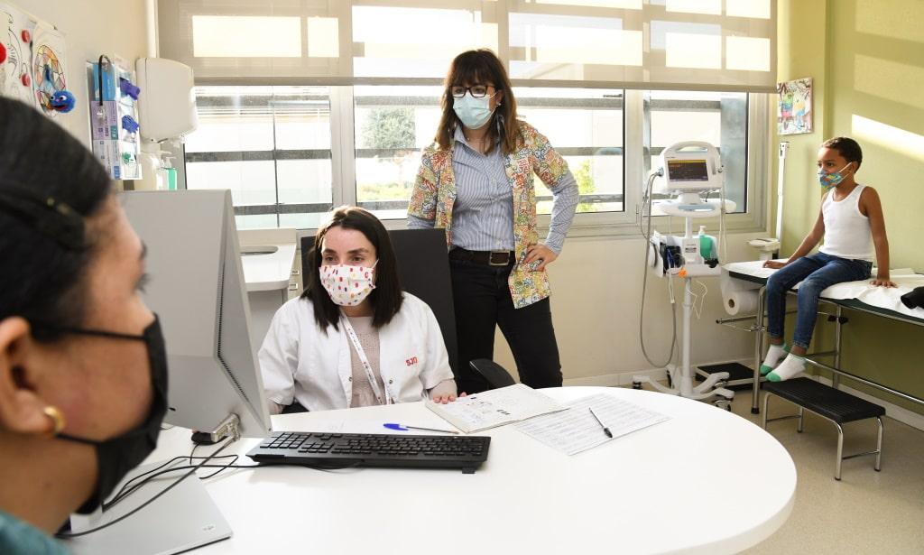 Médico y paciente atienden una familia en consulta Médico y paciente atienden una familia en el Hospital Sant Joan de Déu Barcelona