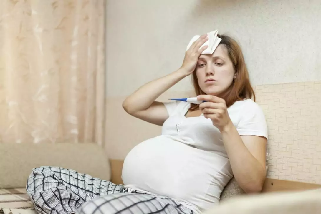 Беременная женщина измеряет температуру