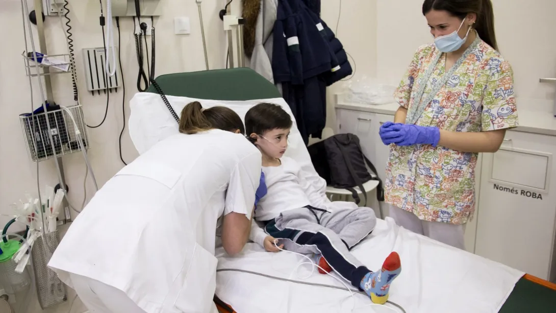 EIR and MIR residents attending to a child at the SJD Barcelona Children's Hospital Medical and nursing resident in a box