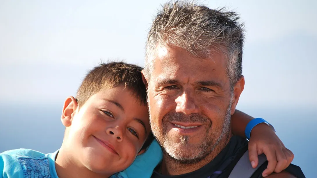 Max, pacient afectat de distròfia muscular de Duchenne, y el seu pare, Jordi Un nen mira a càmera en una fotografia amb el seu pare
