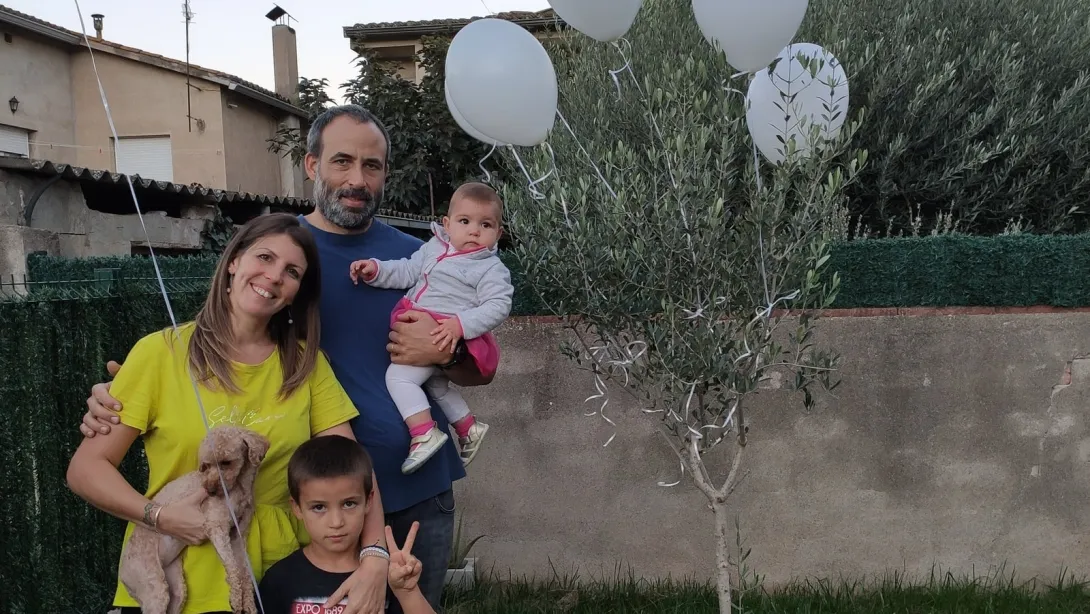 Esther posa junto a su familia en el árbol plantado en memoria de su hijo fallecido Familia junto al árbol plantado en memoria de su hijo fallecido