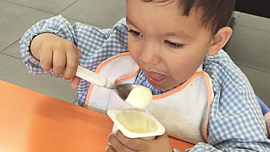 Niño sometido a una intervención de pulgarización del dedo índice, comiendo