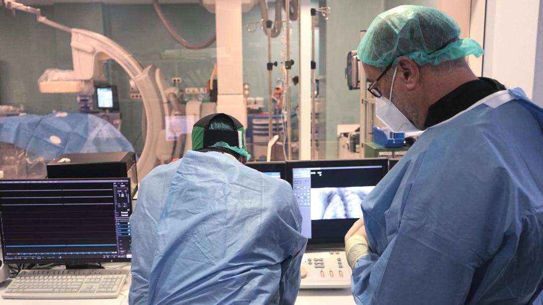 Два хирурга просматривают результаты визуализационного исследования в операционной.
