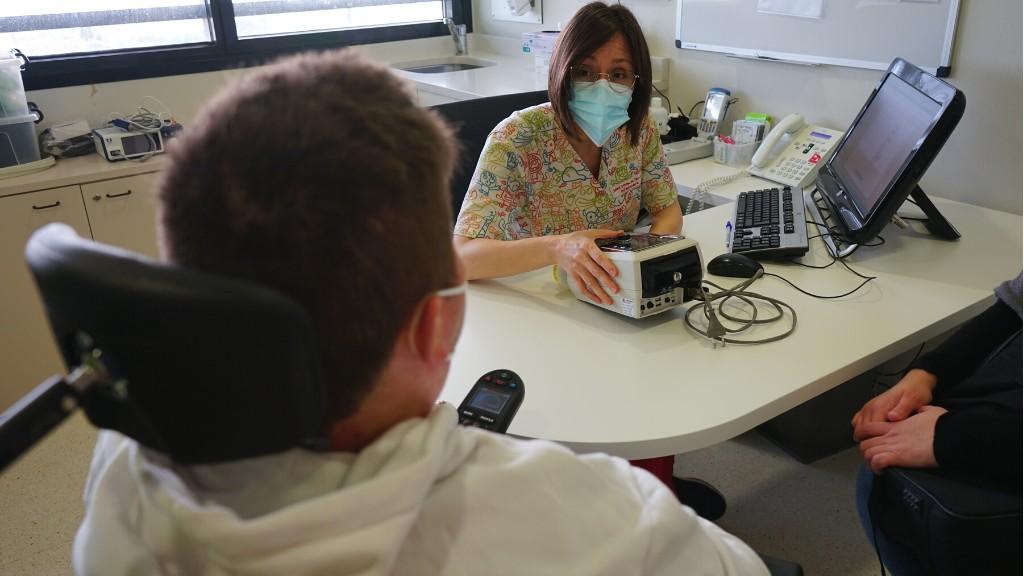 Una infermera i a un pacient comentant l'ús de l'aparell de ventilació domiciliària - Servei de Pneumologia - Hospital Sant Joan de Déu Barcelona