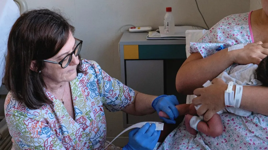 Performing a heel prick test on a newborn Performing a heel prick test on a newborn