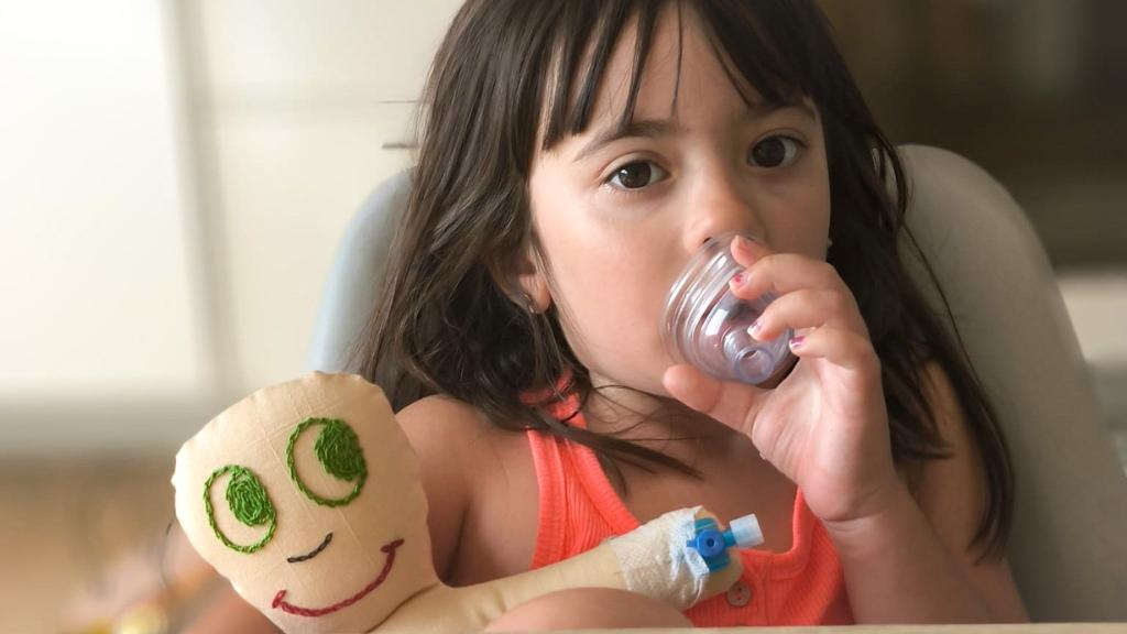 Carla, una niña con autismo, con un muñeco de Child Life