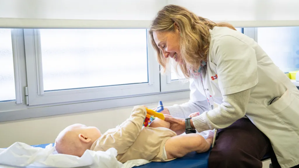 Teràpia gènica OTC a Sant Joan de Déu La Dra. Àngels García amb un nadó a la consulta de l'Hospital Sant Joan de Déu