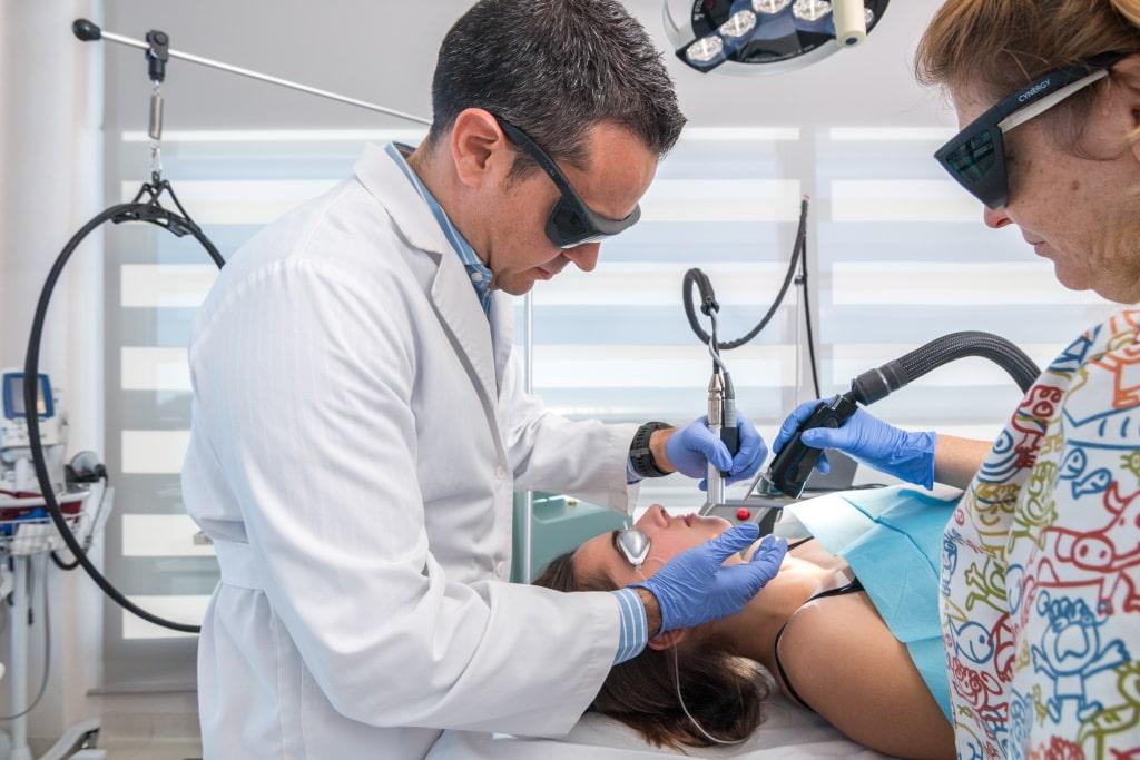 Un dermatólogo aplica la técnica del láser cutáneo para lesiones en la piel en el Hospital Sant Joan de Déu Barcelona