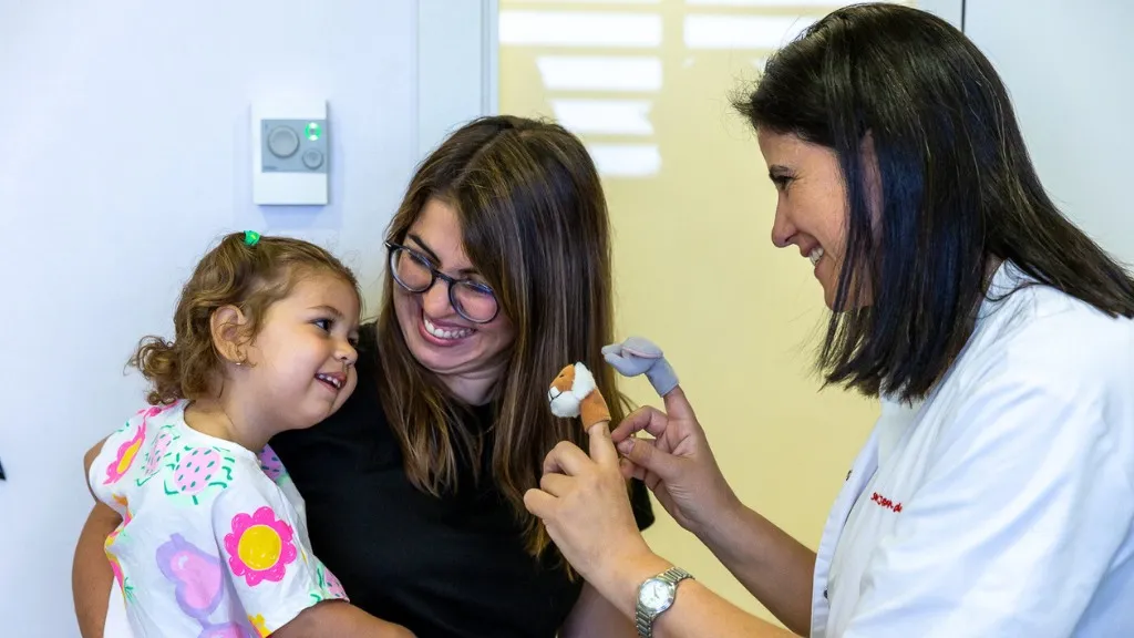 La Dra. Carme Fons en consulta de neurología con una paciente y su madre La Dra. Carme Fons en consulta de neurología con una paciente y su madre
