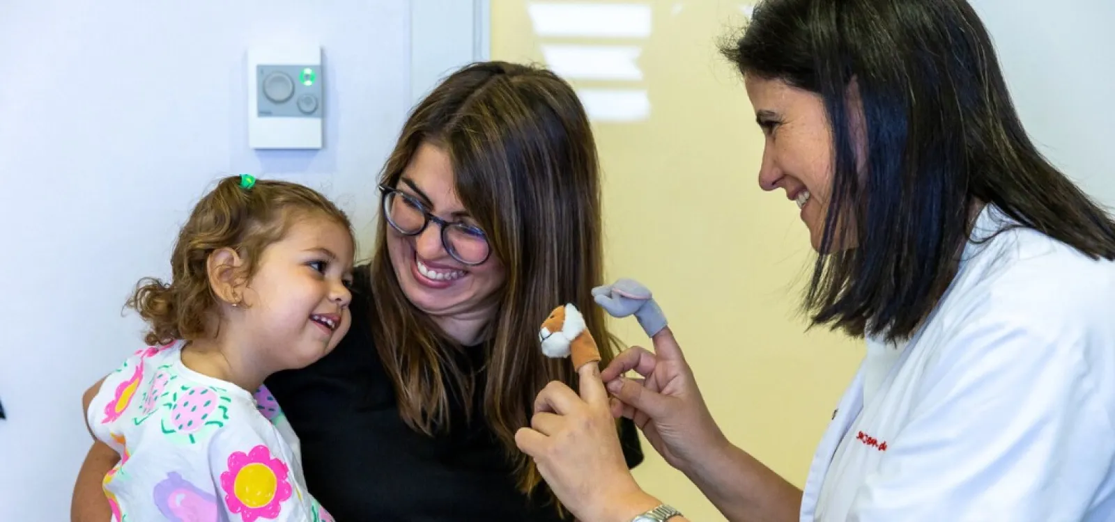 La Dra. Carme Fons en consulta de neurología con una paciente y su madre La Dra. Carme Fons en consulta de neurología con una paciente y su madre