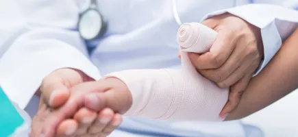Médico vendando brazo de niño Médico vendando brazo de niño