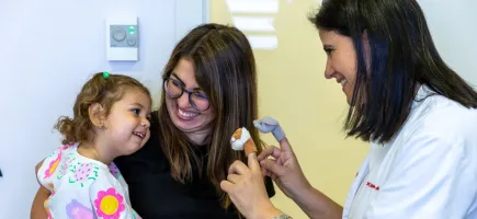 La Dra. Carme Fons en consulta de neurología con una paciente y su madre La Dra. Carme Fons en consulta de neurología con una paciente y su madre