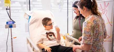 Un paciente participando en un ensayo clínico con un familiar y personal sanitario Un paciente participando en un ensayo clínico con un familiar y personal sanitario