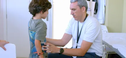 Dr. Alejandro Peiró with a paediatric patient wearing a brace