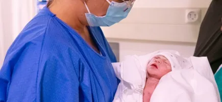 Llevadora sostenint nadó acabat de néixer - Hospital Sant Joan de Déu Barcelona Llevadora sostenint nadó acabat de néixer - Hospital Sant Joan de Déu Barcelona