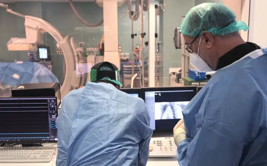 Dos cirujanos revisan una prueba de imagen en quirófano