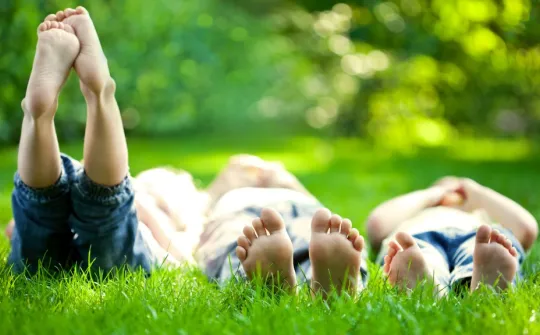 Infants a l'estiu estirats a la gespa