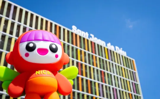 La muñeca Nica delante de la fachada del Hospital Sant Joan de Déu