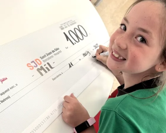 Una niña entrega un cheque en el Hospital Sant Joan de Déu Una niña entrega un cheque con una donación en el Hospital Sant Joan de Déu