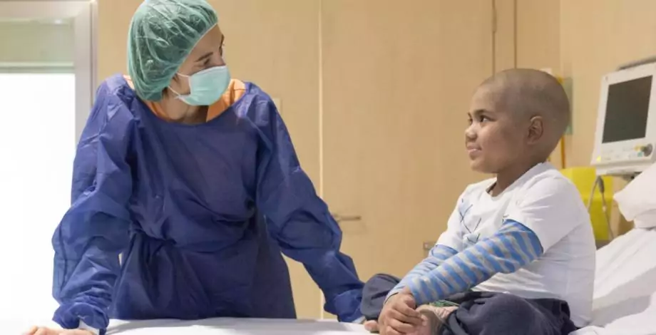 Un nen i una infermera en una cambra d'aïllament de Trasplantament de Progenitors Hematopoètics infantil a l'Hospital Sant Joan de Déu