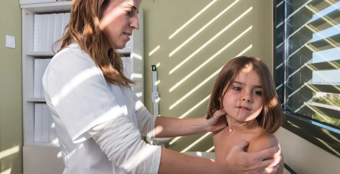 Una médico atiende a una paciente de reumatología pediátrica en el Hospital Sant Joan de Déu Barcelona