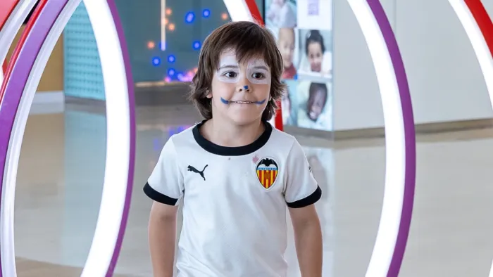 Child with his face painted playing in the lobby of the SJD Barcelona Children's Hospital.