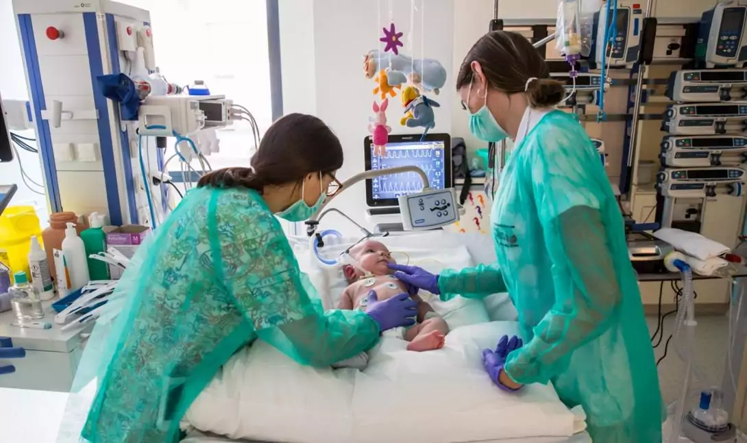 Dos enfermeras cuidan a un paciente en el Área de Cuidados Intensivos Pediátricos del Hospital Sant Joan de Déu Barcelona