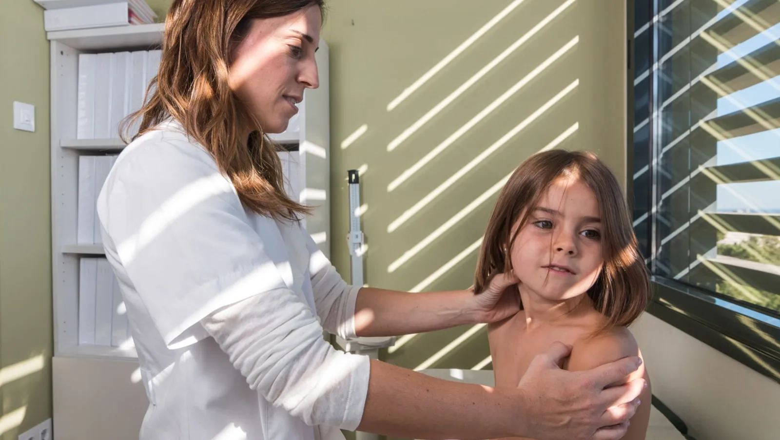 Una médico atiende a una paciente de reumatología pediátrica en el Hospital Sant Joan de Déu Barcelona