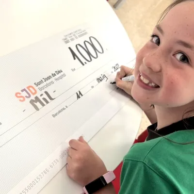 Una niña entrega un cheque en el Hospital Sant Joan de Déu Una niña entrega un cheque con una donación en el Hospital Sant Joan de Déu