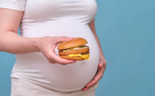 Imagen ilustrativa de una mujer embarazada comiendo alimentos ultraprocesados alimentos ultraprocesados preeclamsia embarazo sant joan de déu