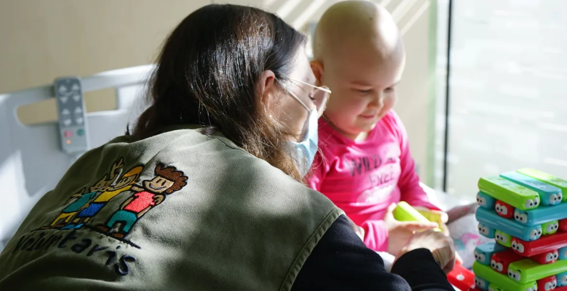 Una voluntaria juega con una paciente en el Hospital Sant Joan de Déu Barcelona