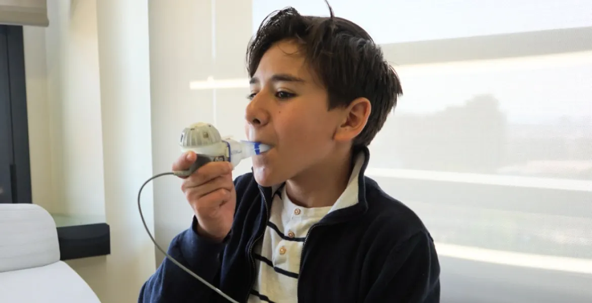 Nen fent servir un nebulitzador a la consulta de fibrosi quística Nen fent servir un nebulitzador a la consulta de fibrosi quística